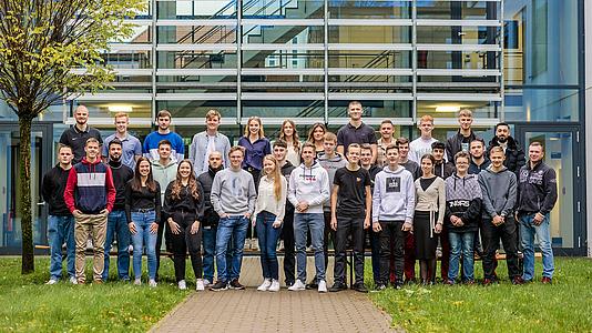 Gruppenbild von jungen Menschen vor dem VOSS Firmengebäude.